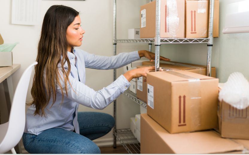 woman in a storage office looking at storage boxes while sitting on the floor