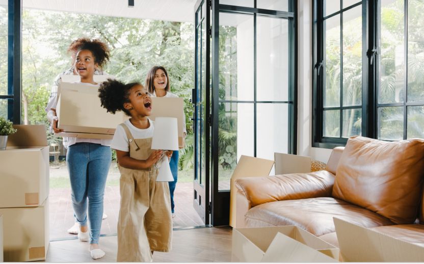 family moving into a home holding storage boxes