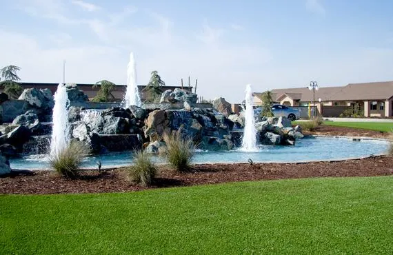 The picture displays a fountain with rocks and active water spouts in front of the 2530 S Clovis location