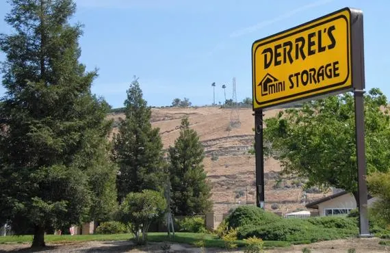 This image shows a yellow sign reading Derrel's Mini Storage