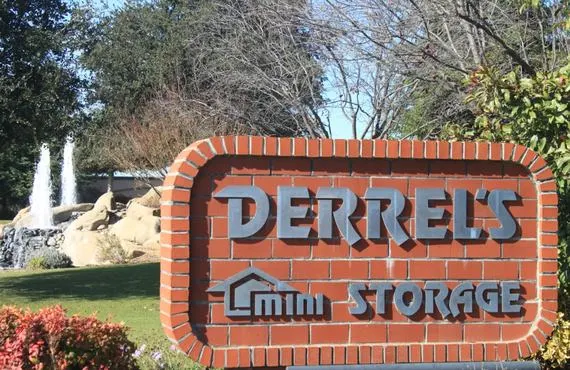 This image shows a brick sign reading Derrel's Mini Storage