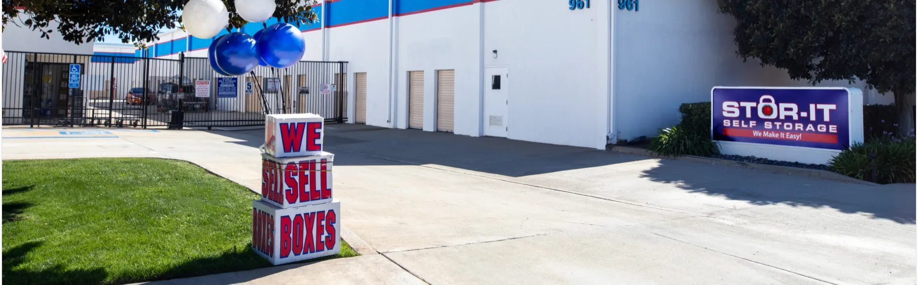 Street view of storage facility with we sell boxes and Stor-it Self Storage Signage