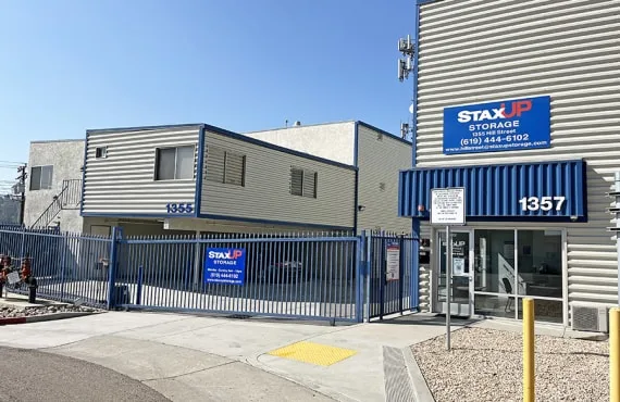 The front office of the property. The gated entrance is closed. Both the office and the gate have a StaxUP Storage sign.