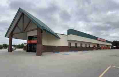 Self Storage building entrance with orange signs that say 'United Spaces Storage' in Skiatook Oklahoma