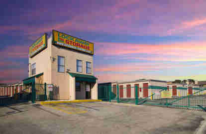 The front office building, labeled with Lockaway Storage signs. The gated entrance is closed. Behind it, exterior storage units are visible.