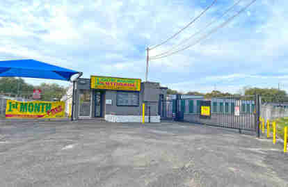 The front of the property, with the front office building and a gated entrance. A banner sign advertises '1ST MONTH FREE'.