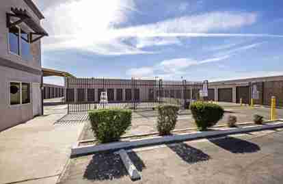 The front of the property. Storage unit buildings sit behind a fence with a sign that says 'WE SELL BOXES'.