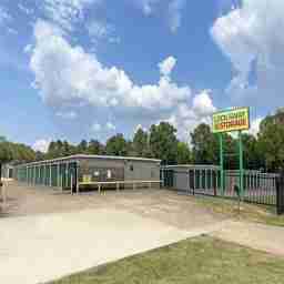 The front of the property, with exterior drive-up storage units surrounded by a fence. A Lockaway Storage sign stands above it all.