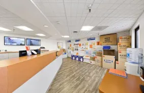 The front office at A-1 Self Storage. Video surveillance screens are visible behind the desk, as well as moving supplies for sale.