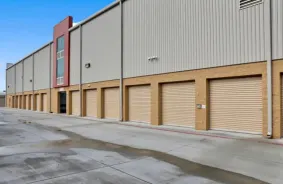 Grey Drive up storage unit with orange roll up doors