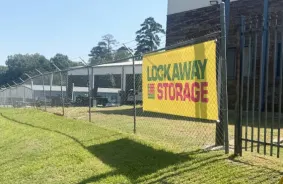 Lockaway Storage banner on gate with covered parking and drive-up storage behind the gate