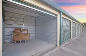 open unit with boxes on a handcart, peachy sunset in background