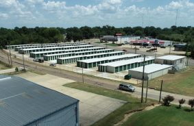 Aerial drone footage of the property, showing rows of exterior drive-up storage units.