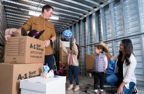 Family inside of a storage unit with storage boxes