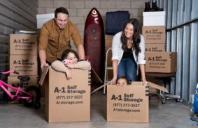 Family inside of a storage unit playing with cardboard storage boxes
