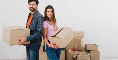 couple wearing various bright colors standing with backs together holding storage boxes