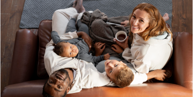 family sitting on couch together smiling