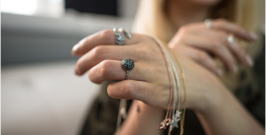 woman with her hand towards the camera ith rings and bracelets on