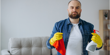 man standing in den with gloves and cleaning supplies