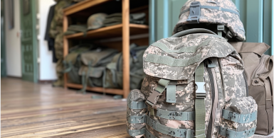 military backpack and hat sitting neatly on the floor