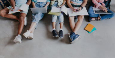 Students sitting with notebooks and laptops