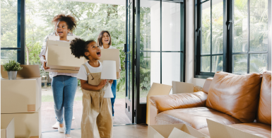 family moving into a home holding storage boxes