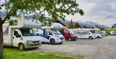 multiple motorhomes lined up while parked outside in the wilderness