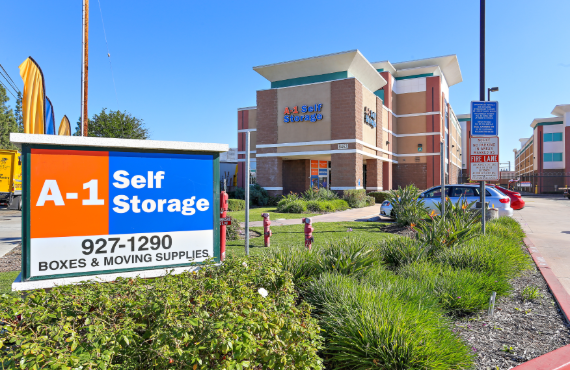 An A-1 Self Storage sign in front of the facility, which advertises boxes and moving supplies for sale.