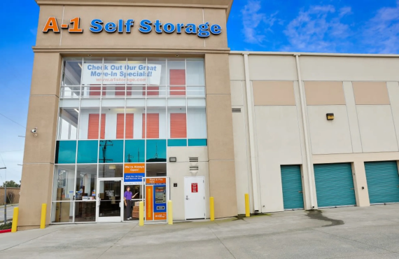 The front of the A-1 Self Storage building. Orange storage unit doors are visible through the windows on the second and third floors.