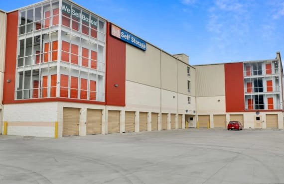 The front of the A-1 Self Storage building, lined with drive-up storage units. A red car is parked outside one unit.