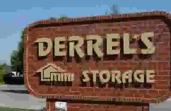This image shows a brick sign reading Derrel's Mini Storage