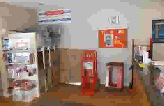 A wall of moving and packing supplies for sale, including dollies, cardboard boxes, and packing tape.