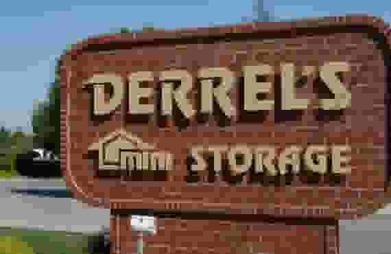 This image shows a brick sign reading Derrel's Mini Storage