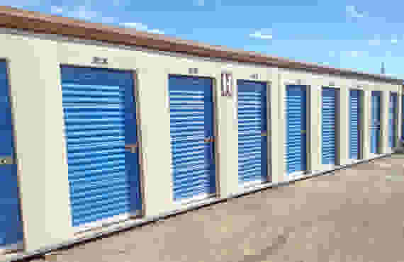 A row of exterior drive-up storage units. The building is labeled 'H'.