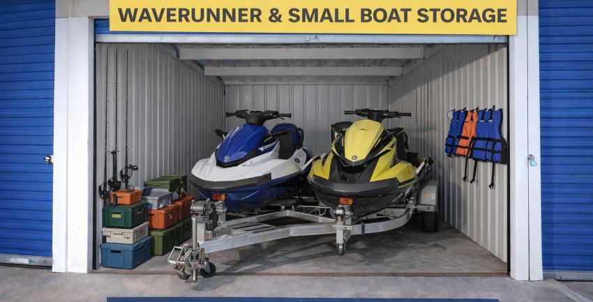 Two WaveRunners on a trailer stored inside a 10x25 storage unit with fishing gear and life jackets at Westward Storage in Walnut CA.