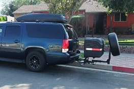 Stowaway cargo carrier on a blue SUV with tire attached