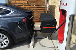 Stowaway box on Tesla at charging station