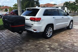 Stowaway cargo carrier on white van parked on pavement