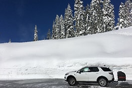 Stowaway cargo carrier on a white SUV on snow mountain