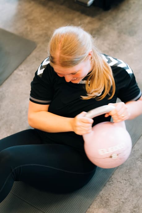 Student trener med kettlebell på treningssenter