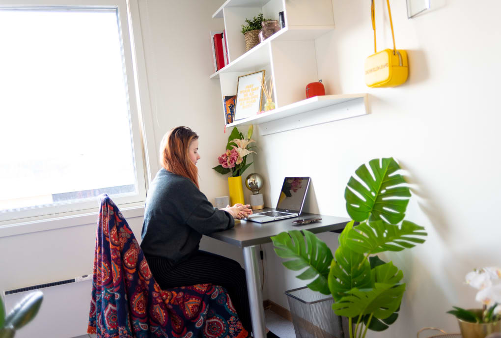 Student ved skrivebord med laptop