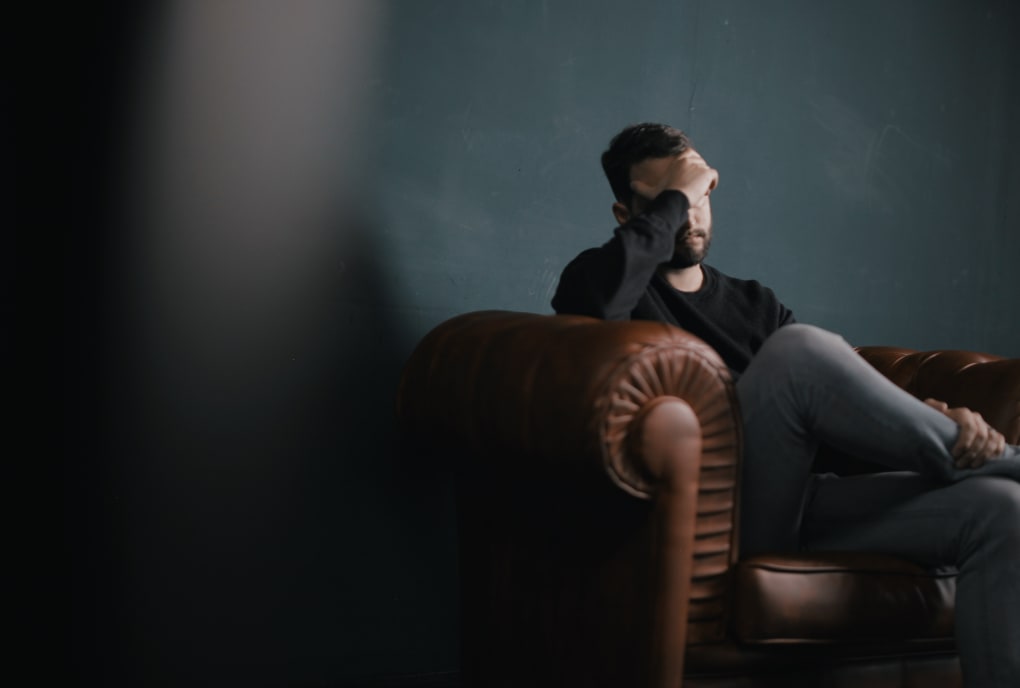 Man sitting in sofa alone looking sad