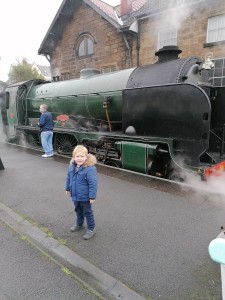 Edward, who has DMD, standing in front of a steam train