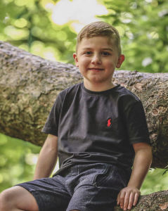 Louis, aged 8, smiling outdoors