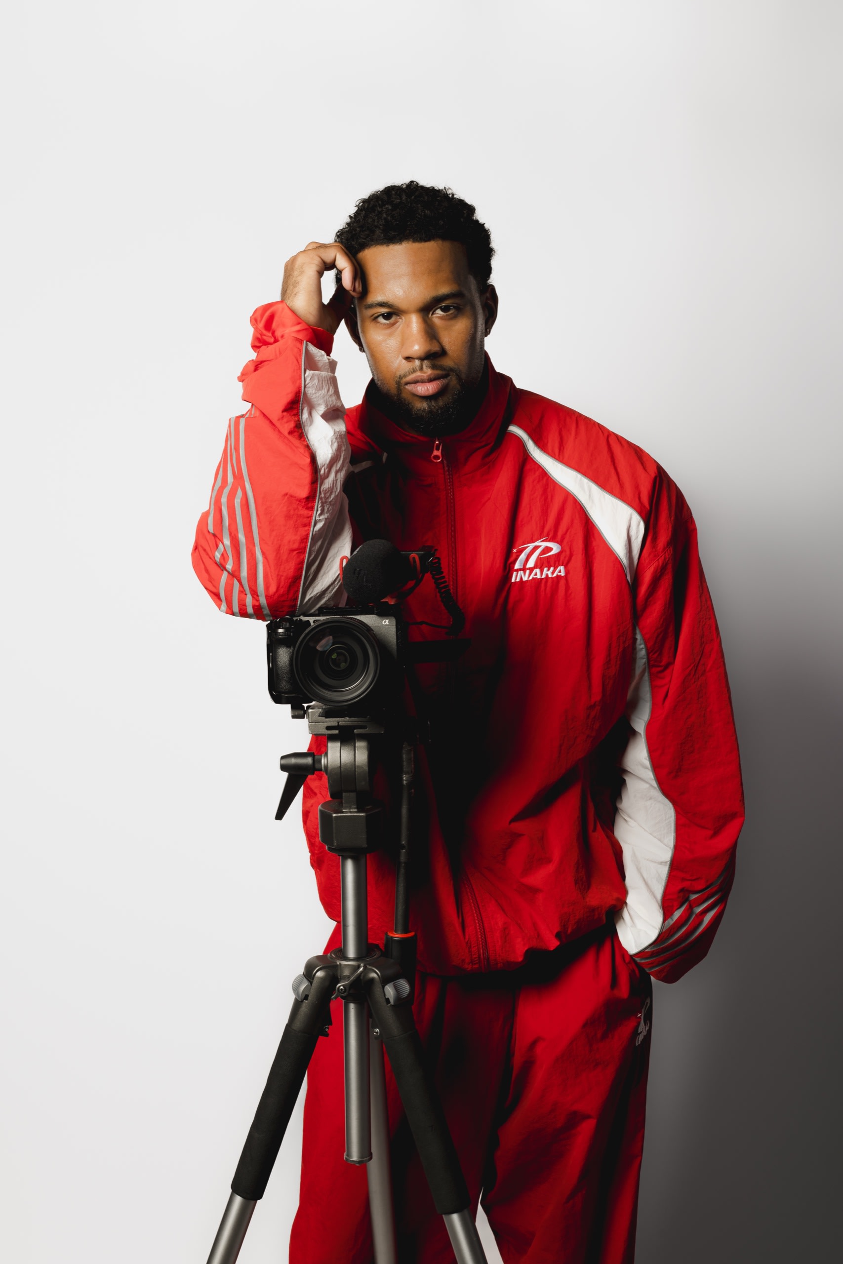 Devante Robinson, founder of Studio 22 Productions, standing beside a cinema camera on a tripod