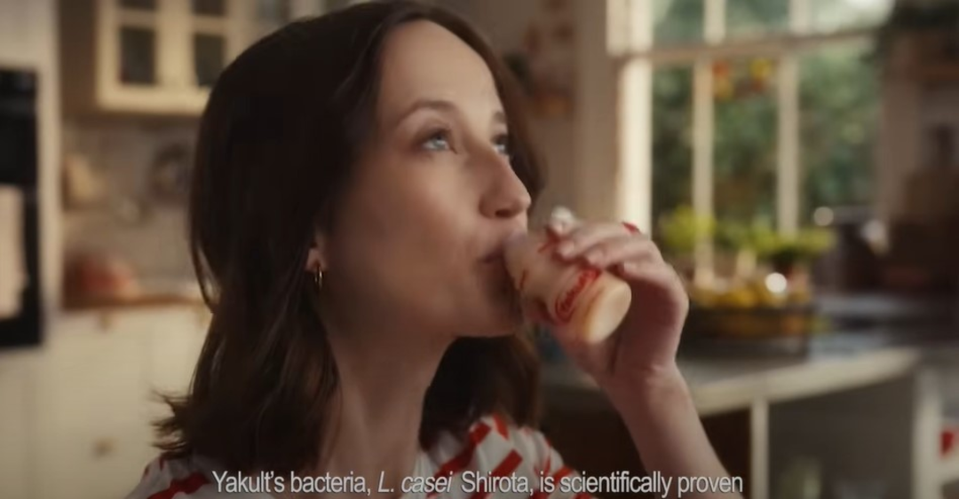 woman driking a bottle of Yakult