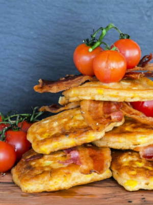 A stack of corn bread with tomatoes and bacon