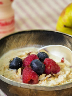 Bowl of porridge with berries and Yakult Original