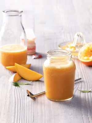 Smoothie met mango, sinaasappels met pers en flesje Yakult Original.