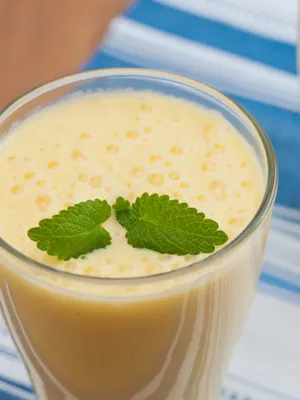 Mango-lassi in een glas met muntje met Yakult.